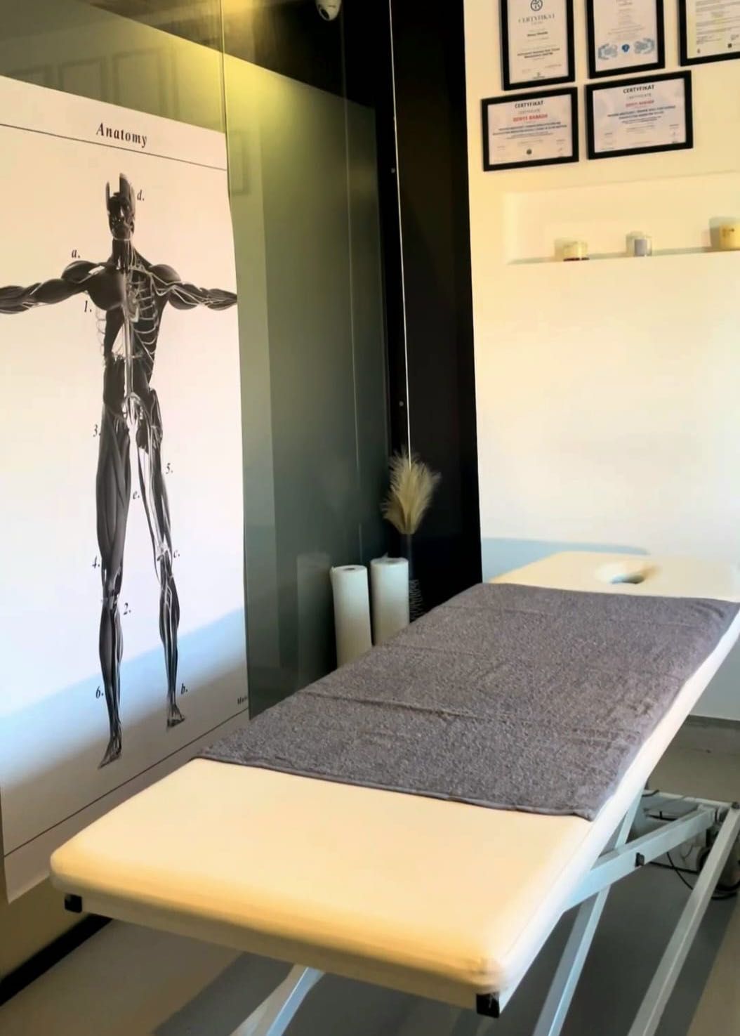 Gabinet Physio Balance na Zabłociu — leżanka terapeutyczna, plansza anatomiczna i certyfikaty